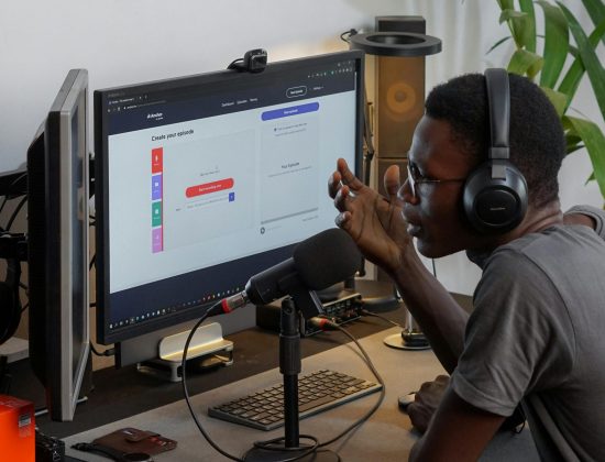 Man using headphones and microphone in home studio, engaging in podcast recording.
